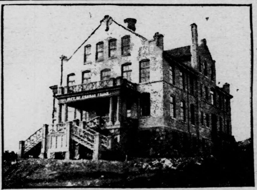A black-and-white photo of a large, old brick building with a front porch, double staircase, and tall windows. The words “House of Refuge, Tampa, FL” are visible above the porch entrance.