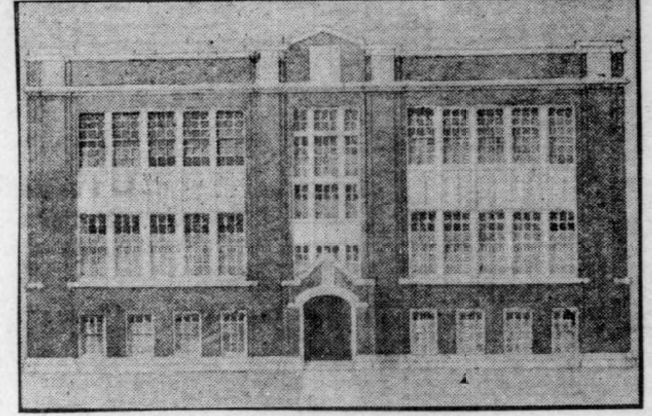 A black and white photo of a three-story brick building with large, evenly spaced windows and a central arched entrance.